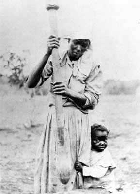 A native Sapelo woman hulling rice with a pestle in the 1920's. Photo courtesy of Sea Island Company.