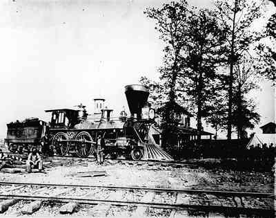 US military railroad engine no. 137,, built in 1864 in the yards of Chattanooga with troops lined up in background.